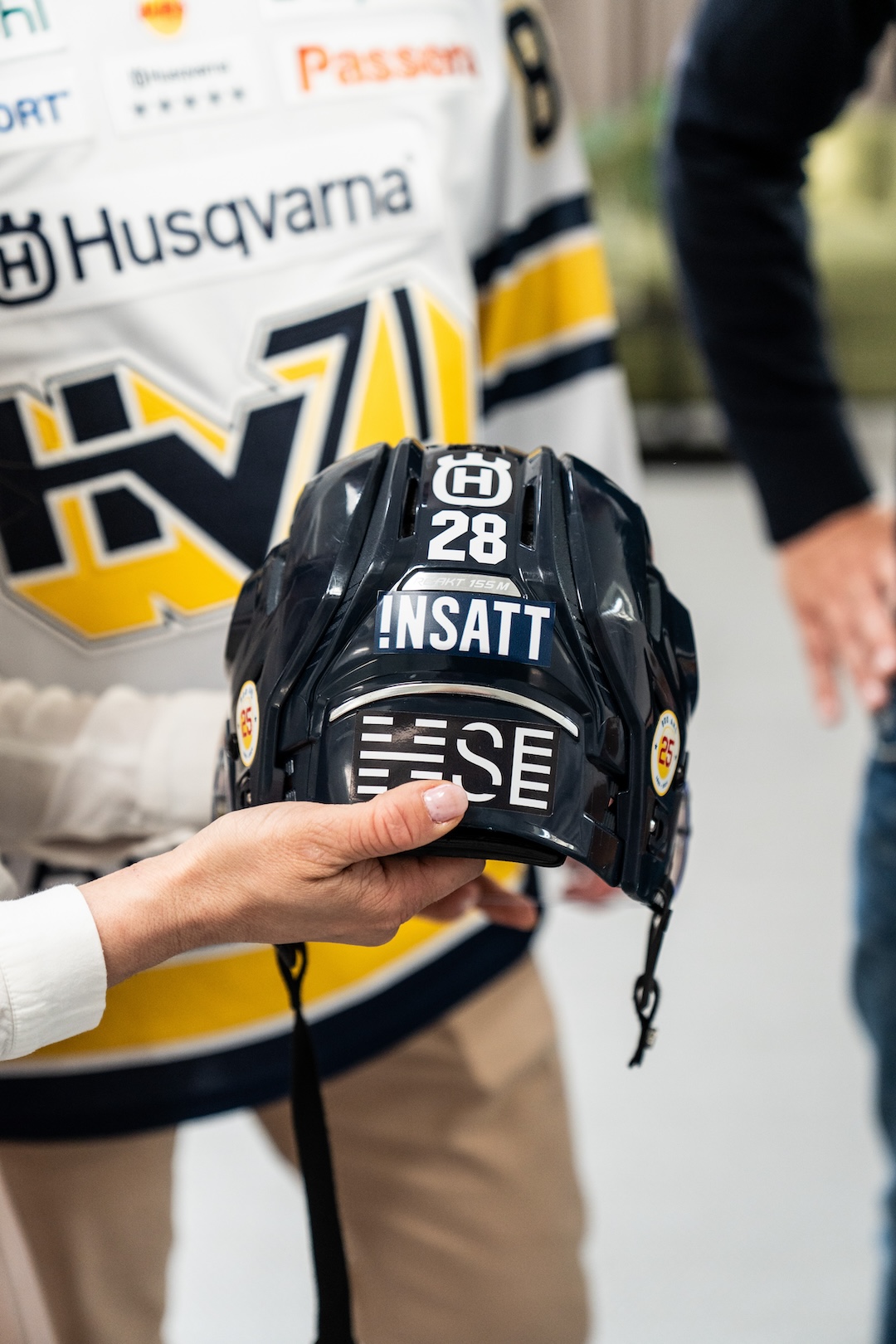 En hockeyhjälm med Insatts logotyp på.